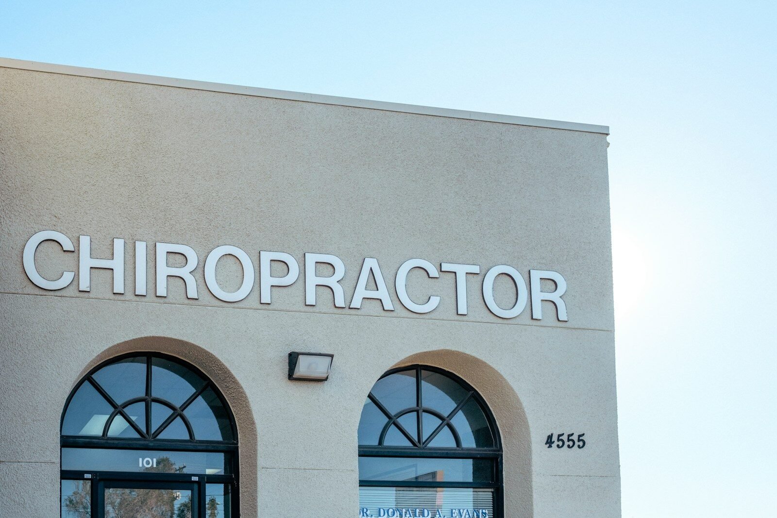 a building with two arched windows and a sign that says chiropractor